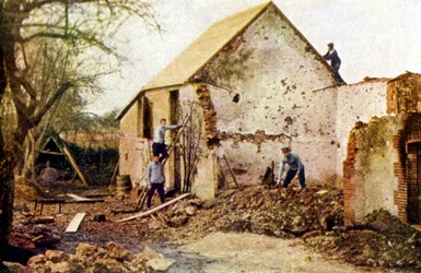 Cuatro hombres trabajando en una casa que fue severamente dañada durante la Batalla del Marne al este de París, septiembre de 1914